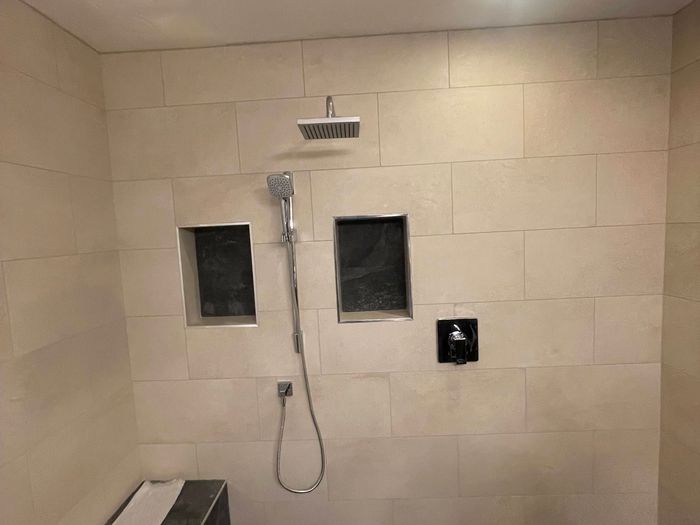 Walk-in steam shower with large-format tile, built-in niches and bench