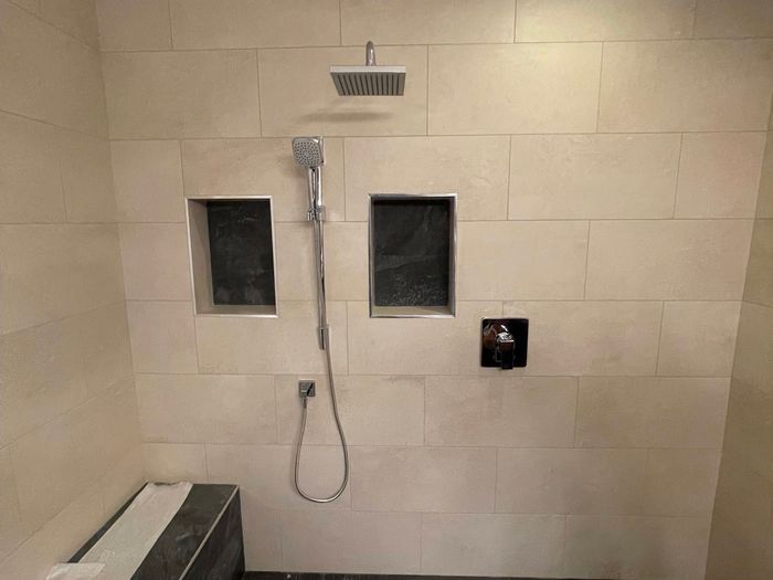 Custom steam shower with hand shower, bench seat and dual niches