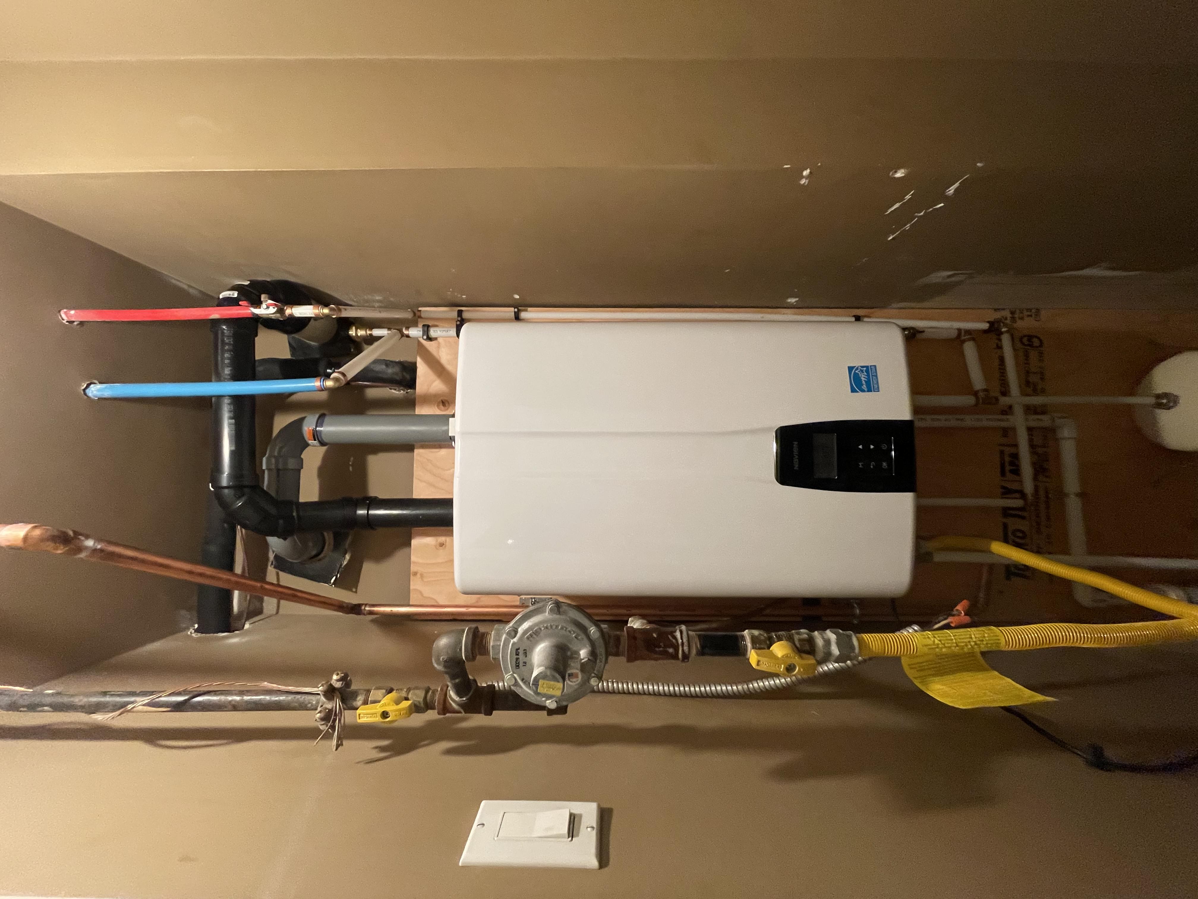 Tankless hot water unit with gas and supply connections, installed by ARSuperfix in Vancouver